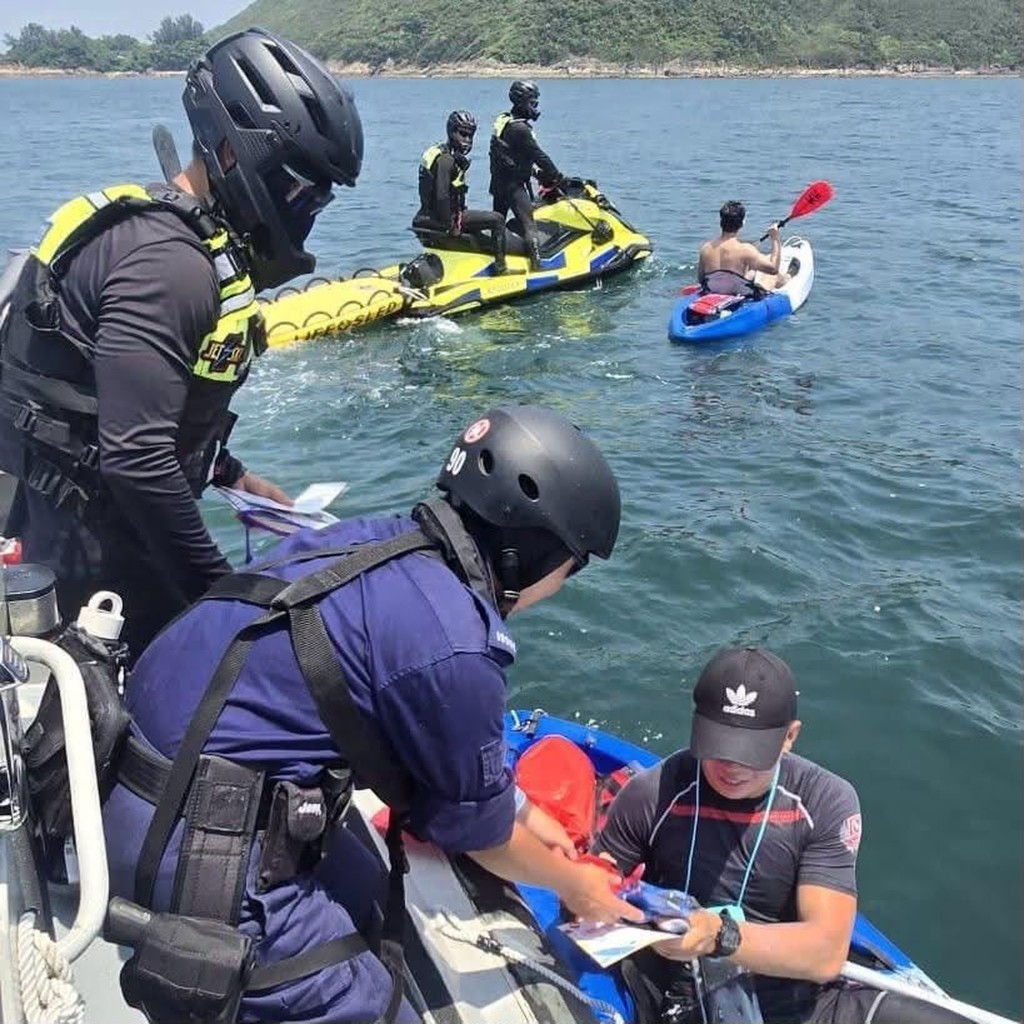 水警人員向正進行水上活動的市民派發宣傳品，提升市民的安全意識。