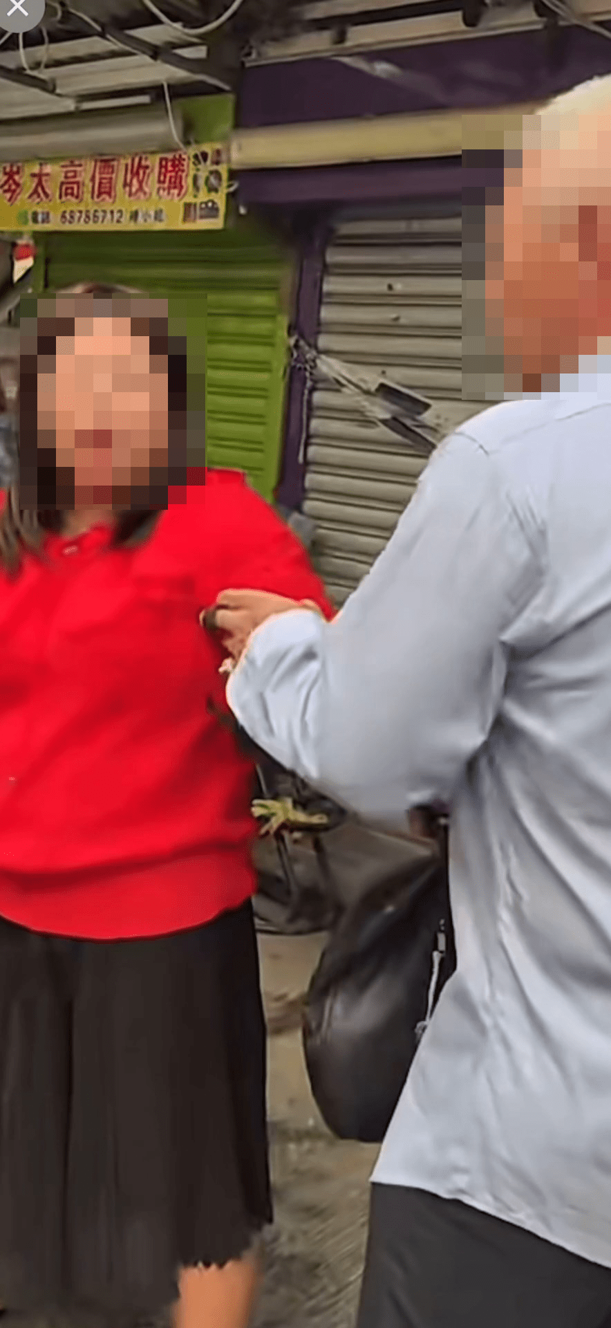 紅衫女子被一名男子捉手，阻止她離開。網上片段截圖