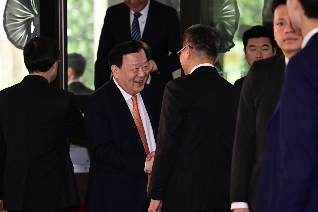 早上约10时半，夏宝龙到政府总部与金融界代表会面。他与财政司司长陈茂波握手。（陈极彰摄）