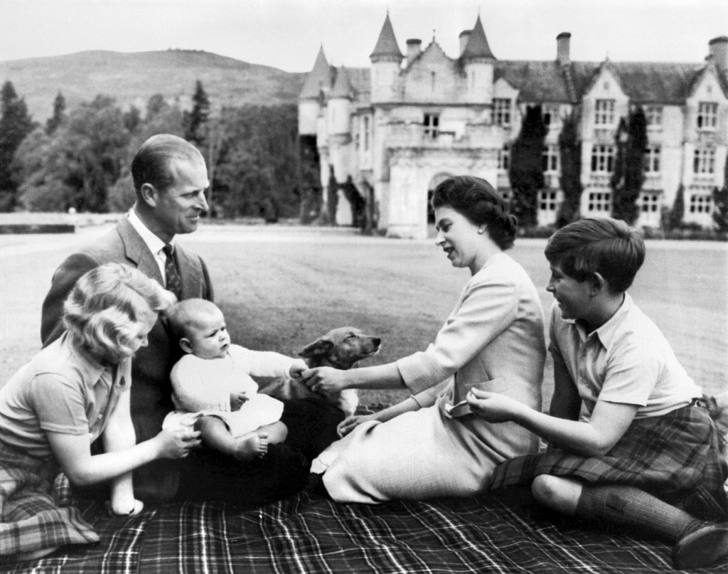 英女皇（右）與菲臘親王（左）、安妮公主（前左）、新生的安德魯王子（中）及新任英國國王查理斯（右），在Balmoral一起跟哥基犬玩樂。（圖片源自法新社）