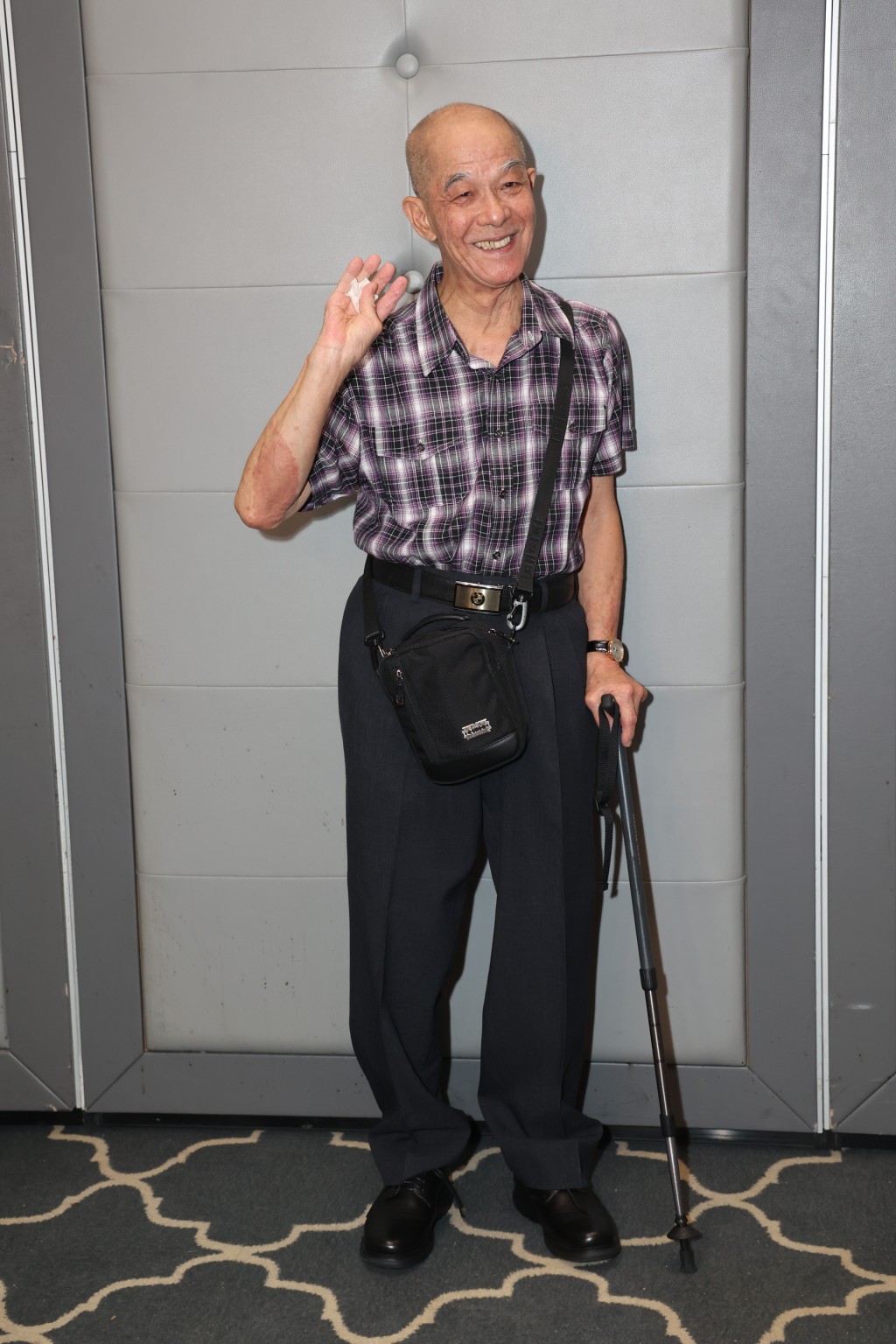 已退休的监制李添胜拄拐杖，步履蹒跚。