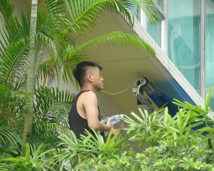 男子不停扭動手中的膠水樽。