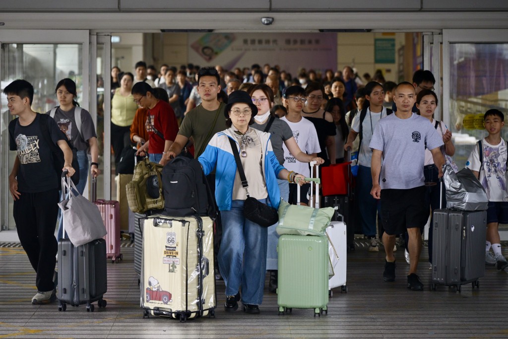 不少一家大小拖著大包小包行李抵港。