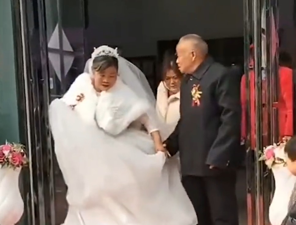 老翁拖著新娘的手步出。