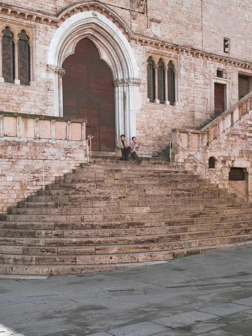 周浩鎮和車茂熙坐在街頭食pizza。