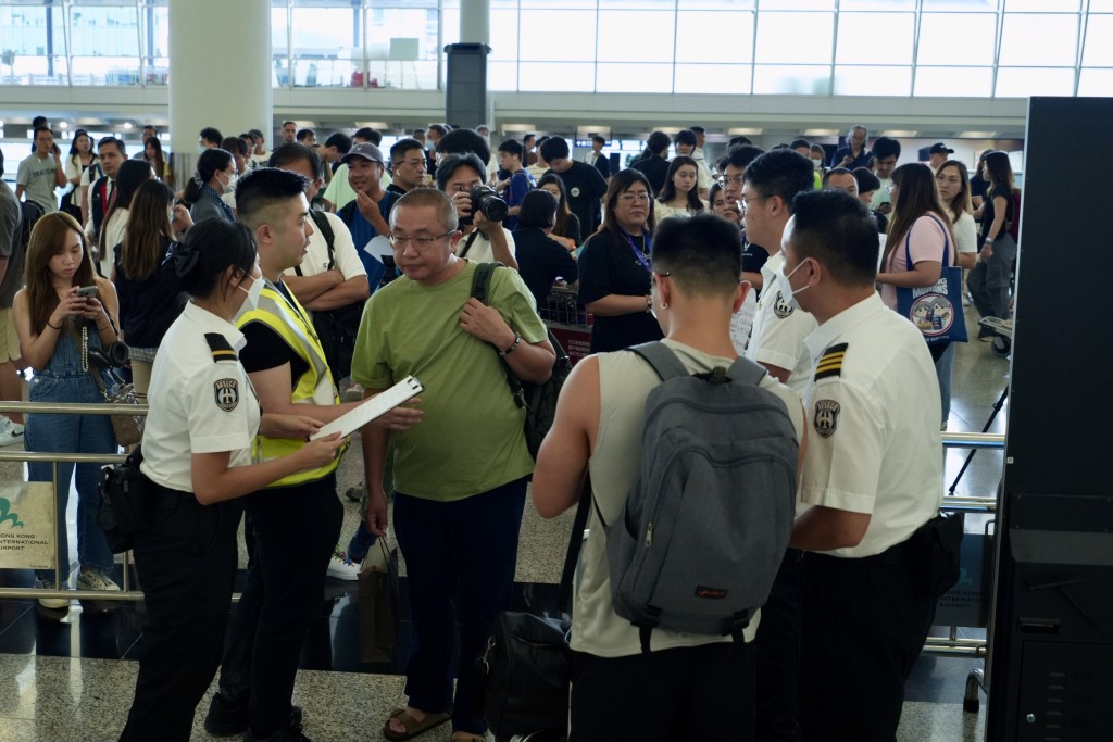 大批旅客在機場離境大堂等待。劉駿軒攝