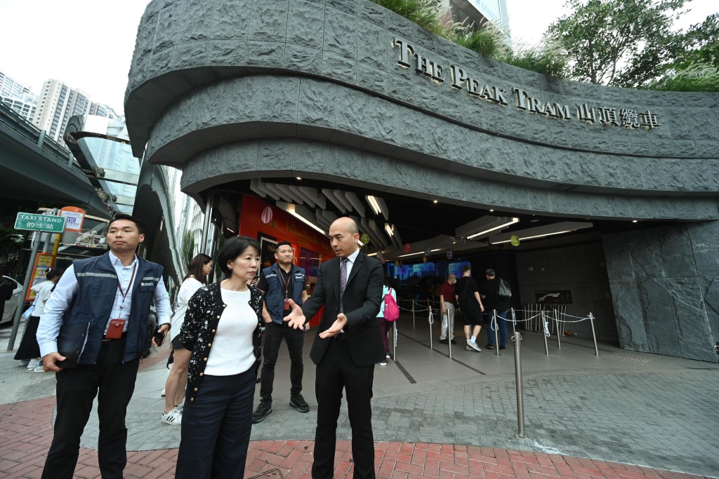 沈鳳君（左一 )等到花園道山頂纜車站，視察景點在周迎接旅客的人流管理安排。政府新聞處