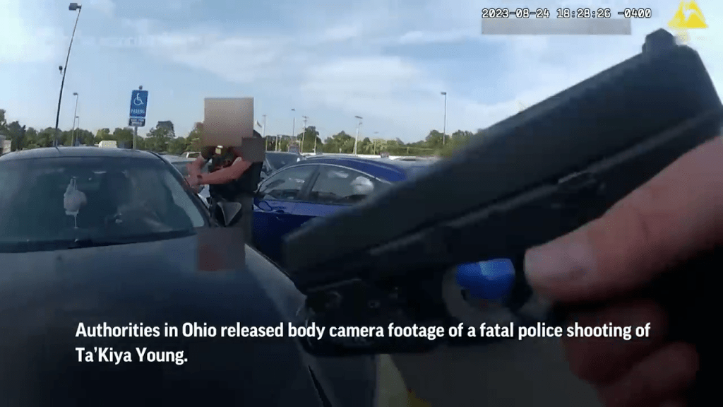 另一名警員站在汽車前方，左手放在引擎蓋上，右手拔出手槍。