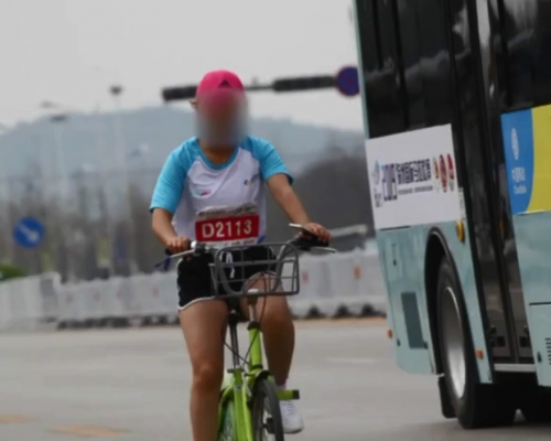 一名女選手以單車參與馬拉松賽事。 影片截圖