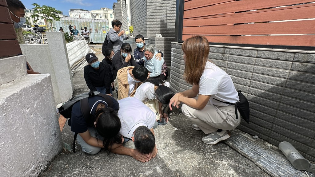 藍秀珍慘遭倒塌圍牆壓斃，其丈夫和3名子女等家屬日前在現場跪地痛哭。 資料圖片