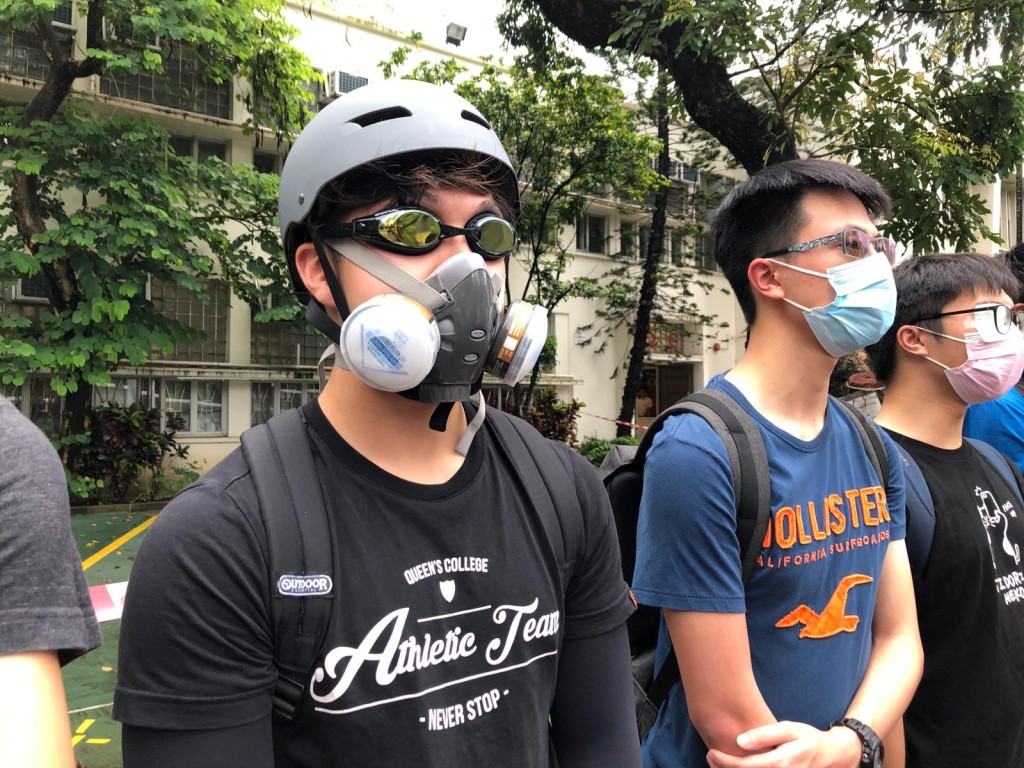 趙先生以頭盔、泳鏡及豬嘴裝扮回到母校，與師弟們一同高呼口號。