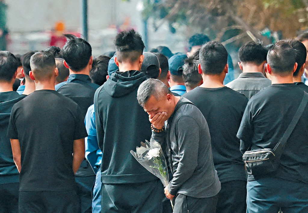 殉職消防員的家屬朋友在起火現場外進行「頭七」路祭，有人掩面痛哭。