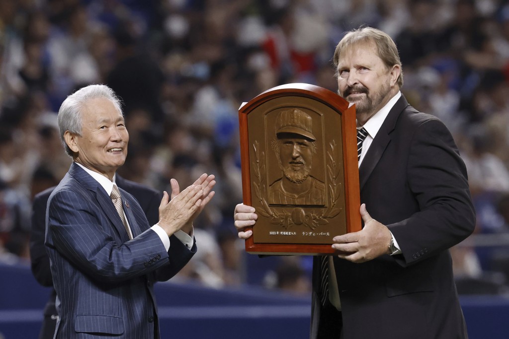 巴斯（右）曾在日本職棒球隊效力多年，去年在入選日本棒球名人堂的儀式上被授予牌匾。 美聯社