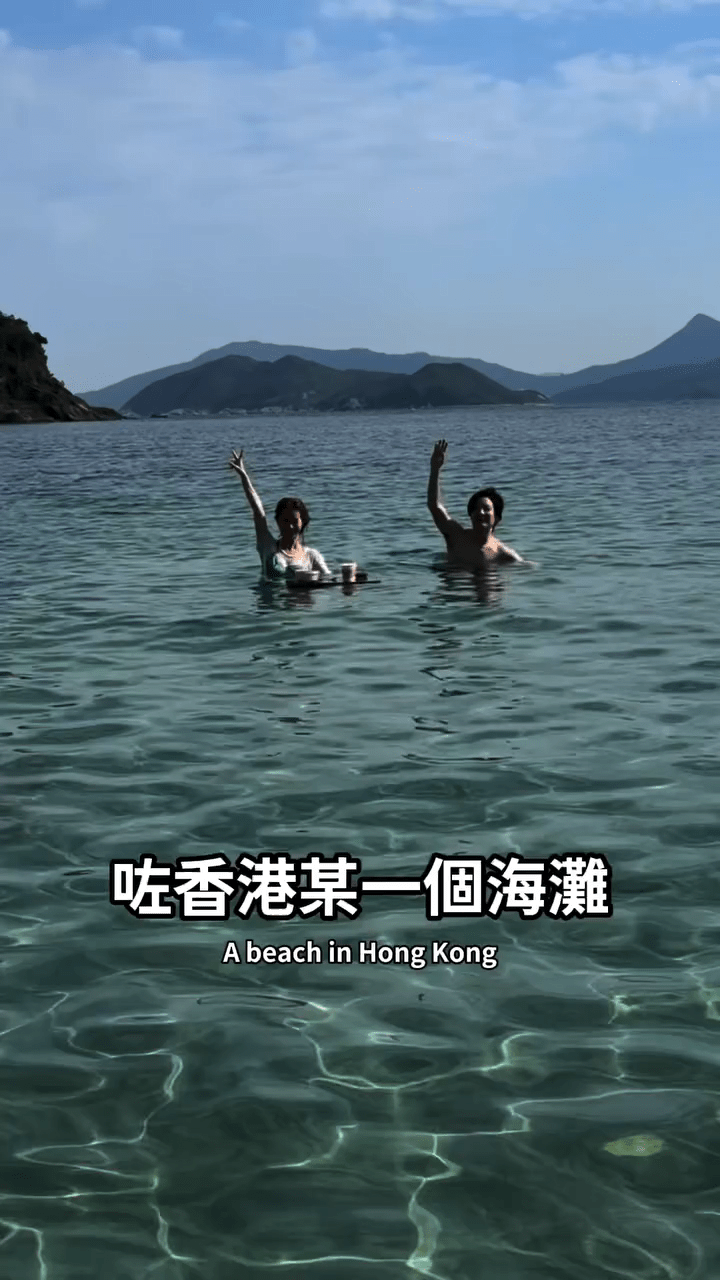 兩人在香港某個海灘暢泳，享受陽光與海水的愜意時光。