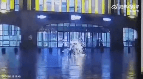 两旅客打伞路经辽宁锦州北站遭雷击。