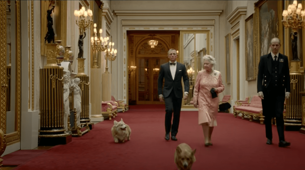 2012年伦敦奥运开幕短片，英女皇与其爱犬Willow、Holy及Monty，跟电影《007》男主角Daniel Craig 一同粉墨登场。（图片截取自YouTube）