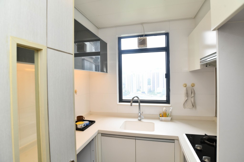 廚房有多組白色廚櫃，可收納多種物品。