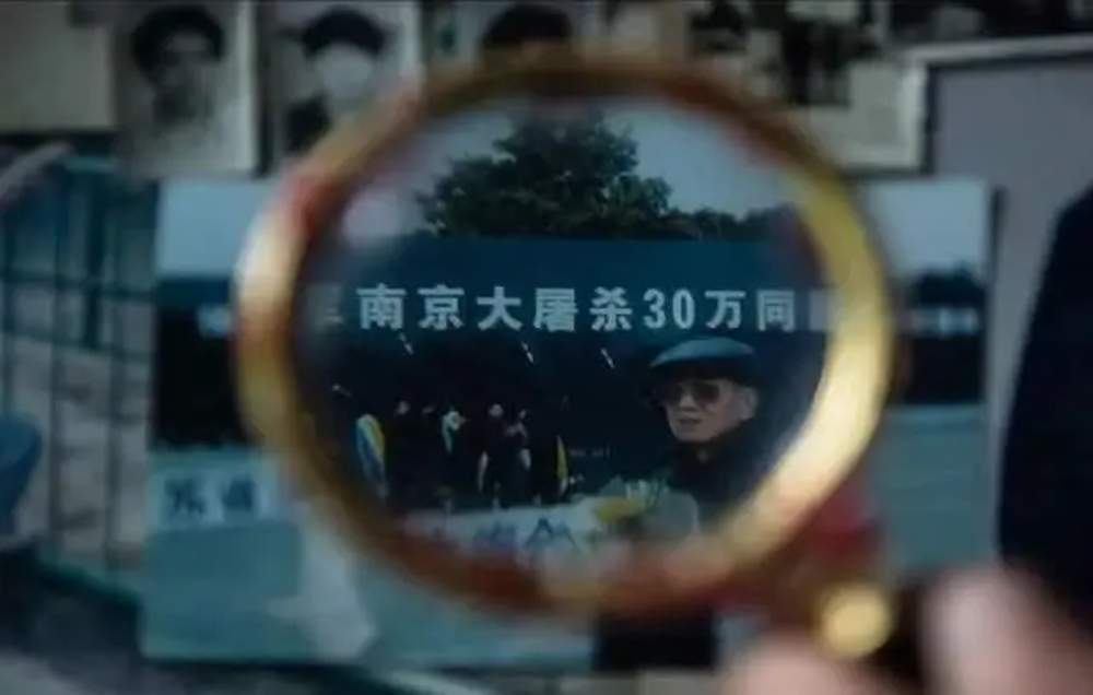 馬庭祿生前用放大鏡檢視自己在紀念館參加紀念活動的照片。
