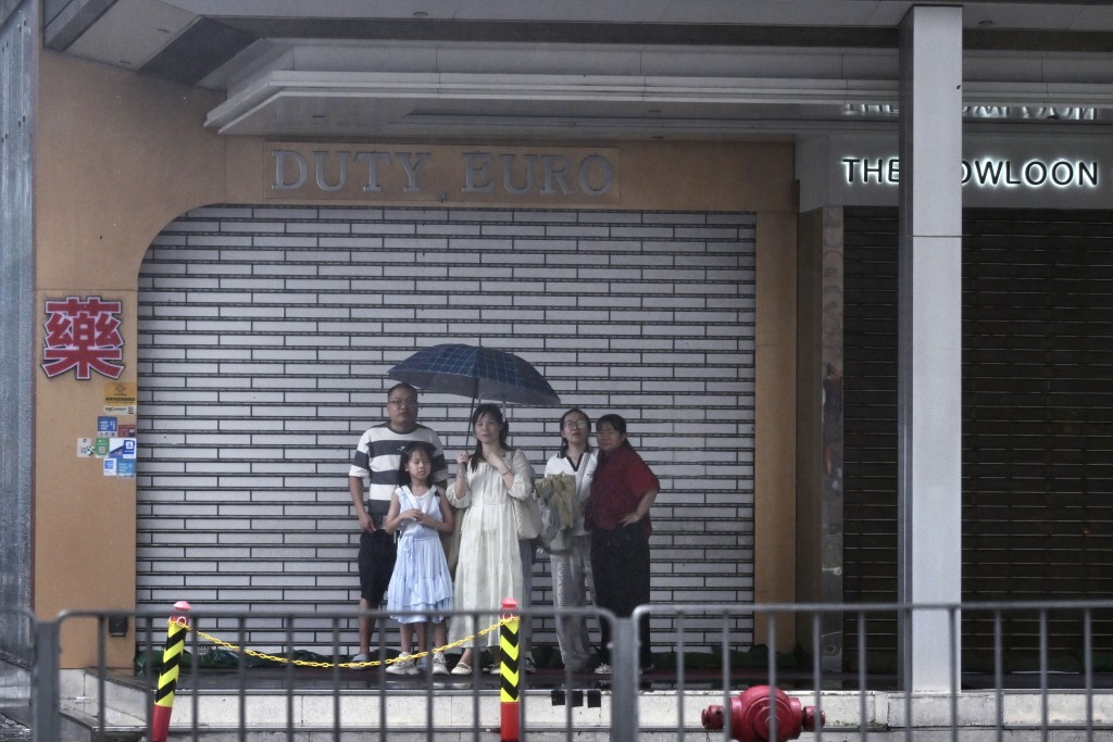 有遊客在騎樓底避雨。劉駿軒攝 有遊客在騎樓底避雨。劉駿軒攝