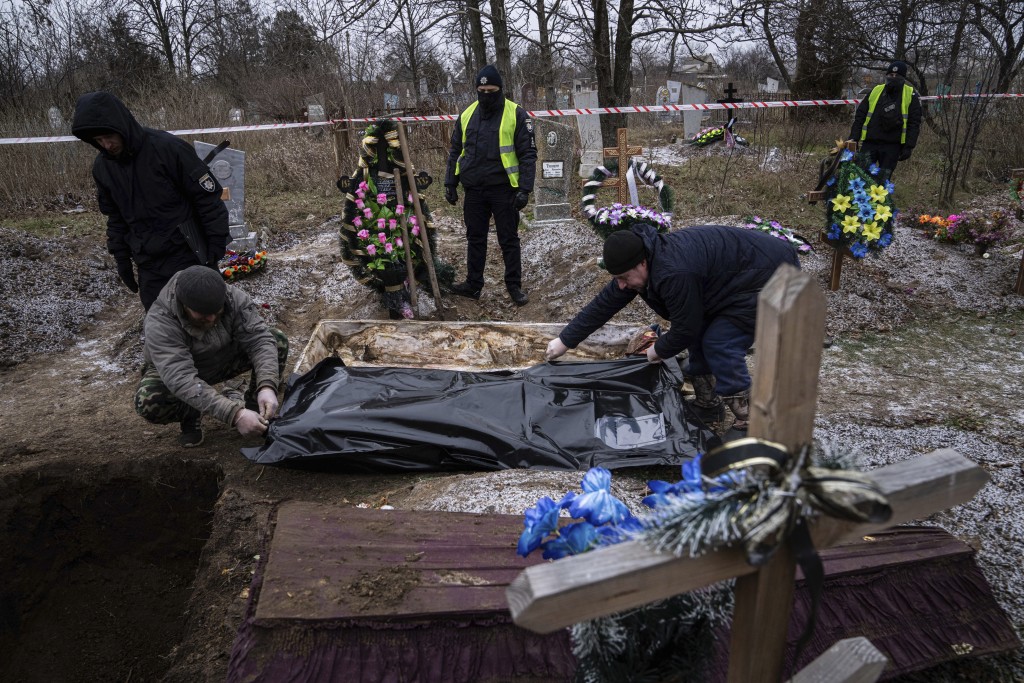 在最近被收復的烏克蘭Vysokopillya鎮的舊墓地，葬禮工作人員正在處理屍體。AP