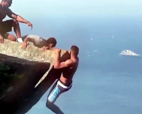 巴西有男子崖邊拍照，況狀驚險。影片截圖