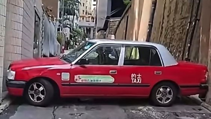 的士「打橫」被困在兩幅石牆之間。fb「車cam L（香港群組）」影片截圖