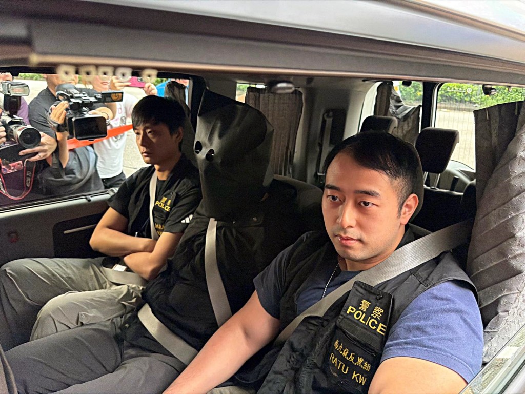 探員押解黑布蒙頭的「左口」。曾志恆攝 探員押解黑布蒙頭的「左口」。曾志恆攝