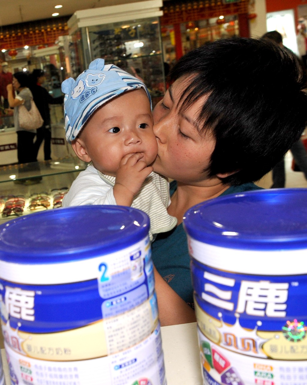 宁夏银川一名妇女带着孩子到超市办理三鹿奶粉退货。 新华社