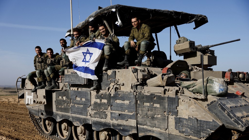 以色列士兵在車上揚起國旗。 路透社 
