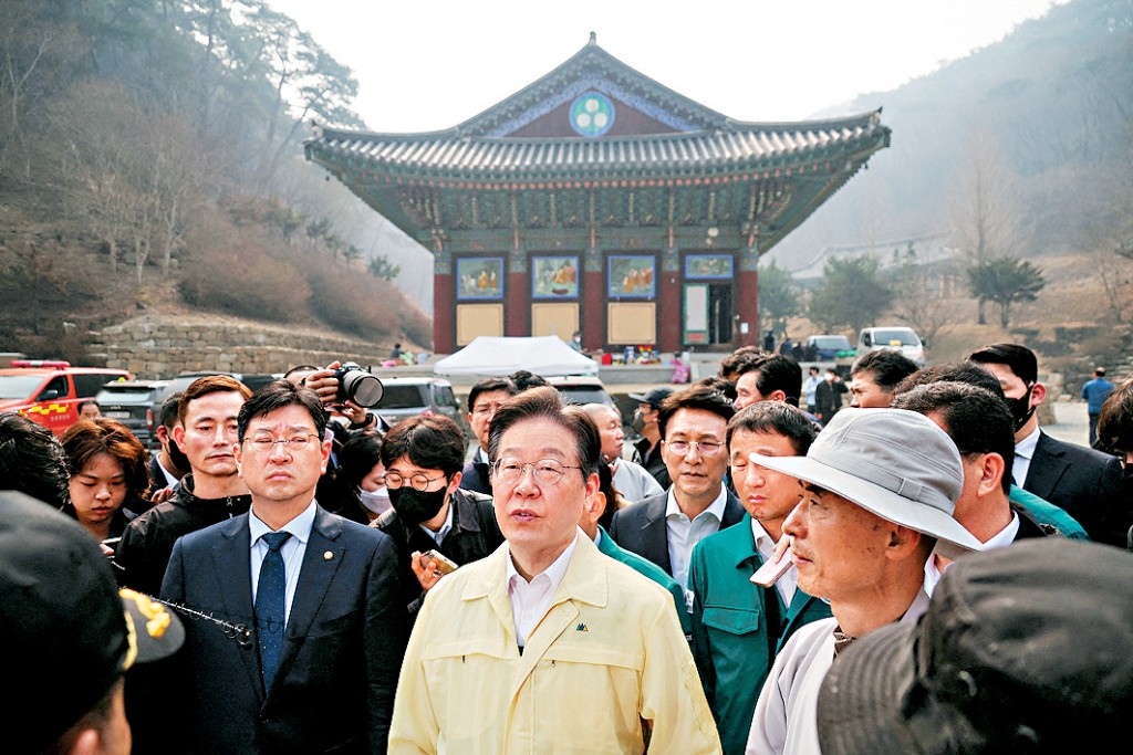 在野共同民主黨黨魁李在明(中)上月底視察被山火燒毀的孤雲寺。