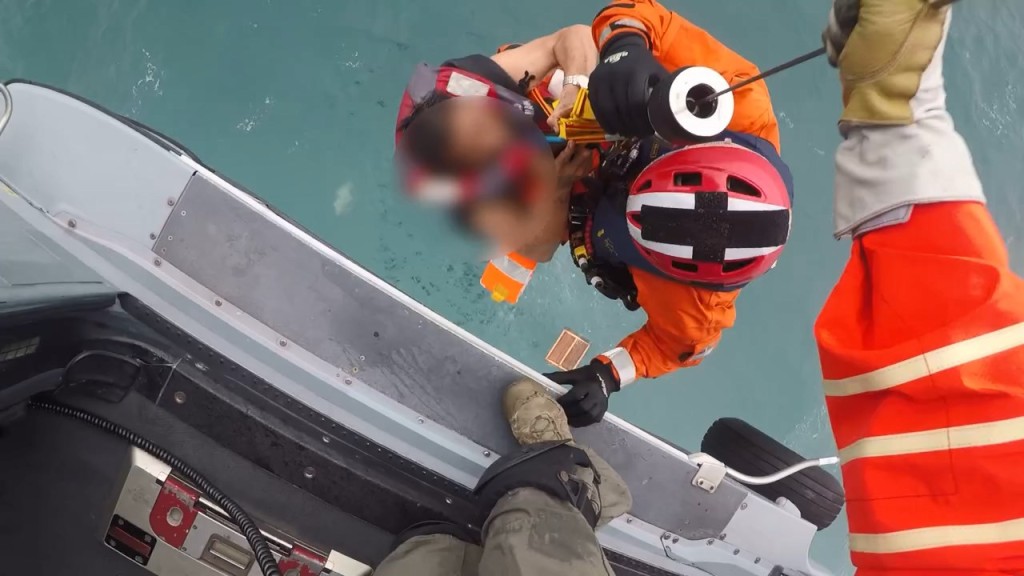 飛行服務隊人員冒着狂風將兩名被困海中央的船員救起。