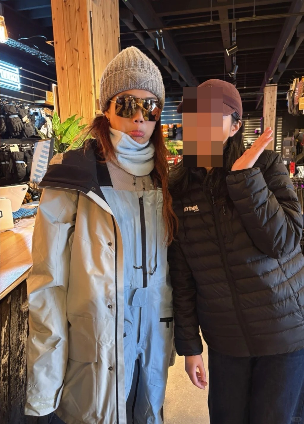 染著金棕色长直发的容祖儿身穿浅蓝色高领上衣及浅灰色连帽滑雪服，并佩戴浅灰色冷帽及银色亮面墨镜，整体造型既保暖又型格。