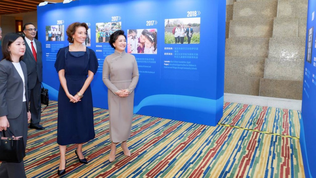 彭麗媛和阿祖萊(中)觀看教科文組織的圖片展。新華社