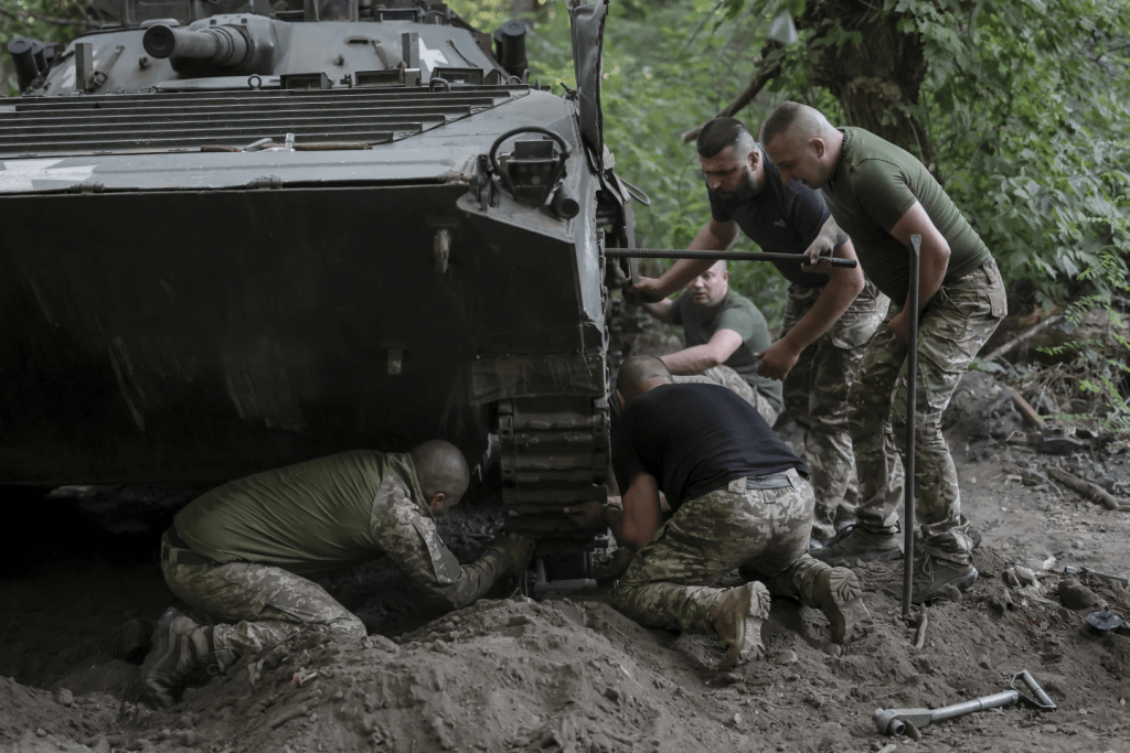 有士兵在修理坦克車。（美聯社）