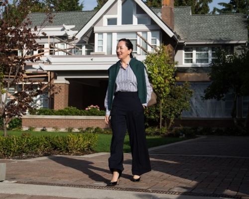 孟晚舟穿上恤衫、長褲和綠色背心外套，到達法院，神情輕鬆。AP