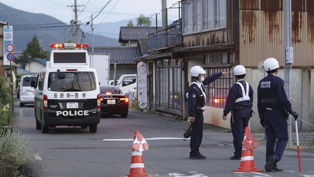 日本長野縣中野市發生槍擊案，疑犯躲入民宅，警方在通往民宅的路上駐守。 美聯社