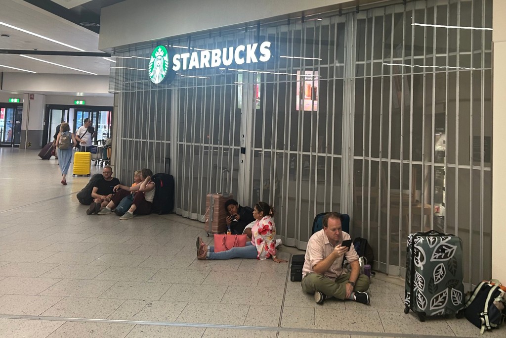 由於酒吧和餐廳關閉，座位短缺，旅客只能坐在地板上。美聯社