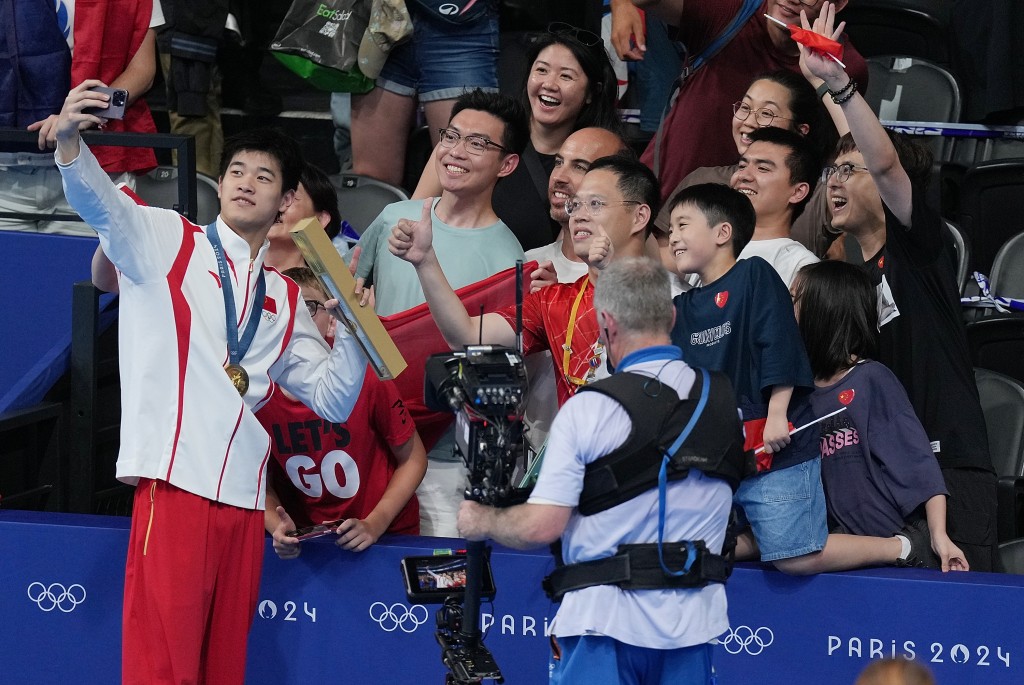 潘展樂破世績奪100米自金牌，與支持者自拍。新華社