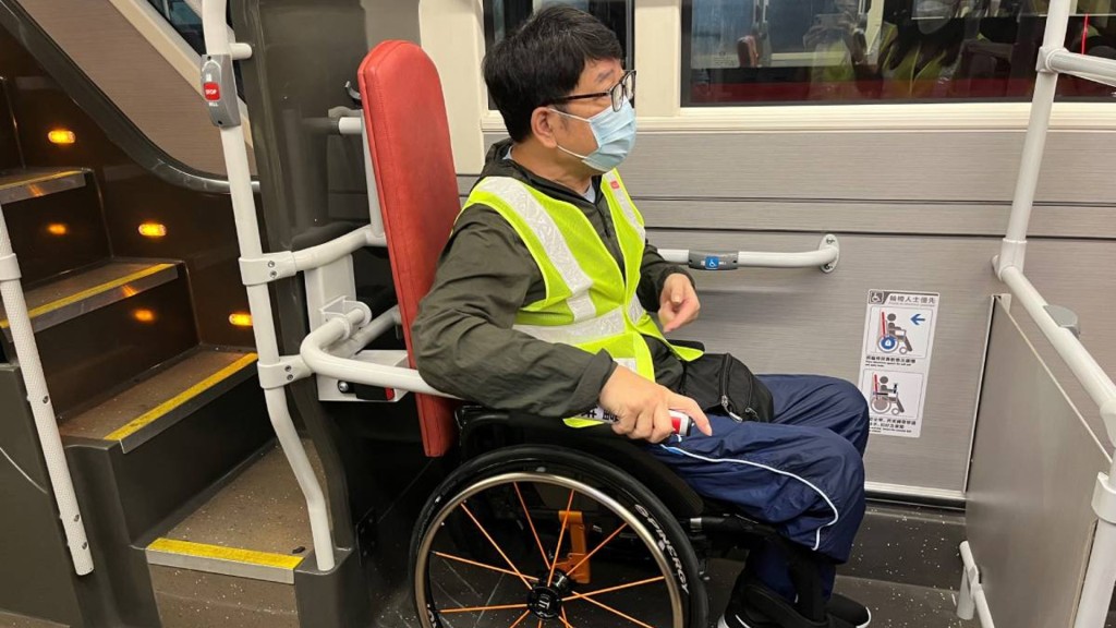 香港復康力量董事伍強試用新的扶手，認為新設施可以保護輪椅乘客。九巴圖片