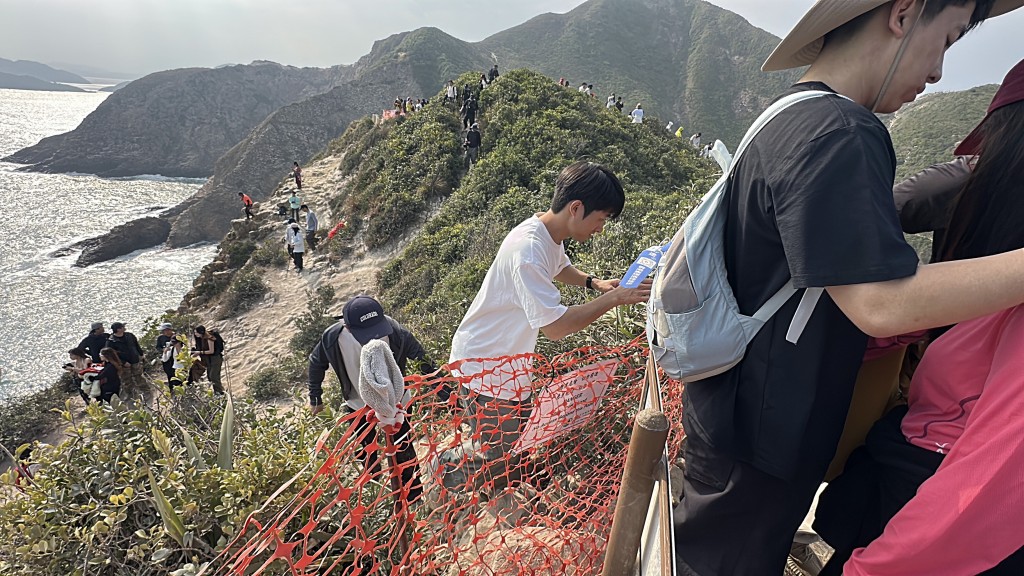 不少遊人無視警告,跨過圍障走近懸崖。劉漢權攝 不少遊人無視警告,跨過圍障走近懸崖。劉漢權攝