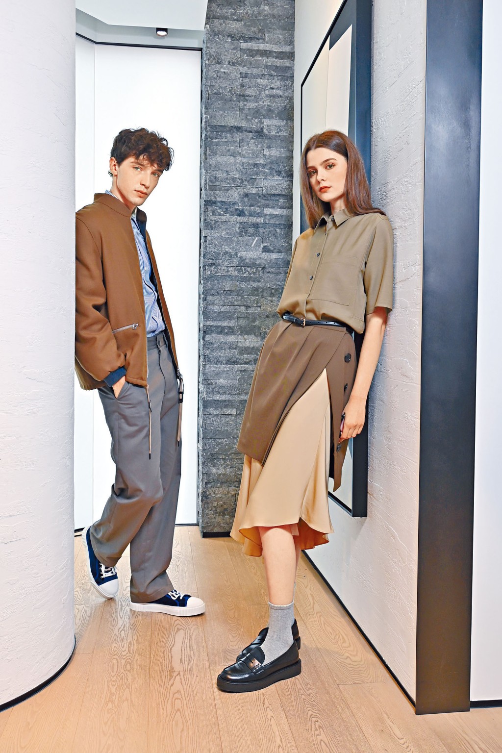 On Eugene：啡色羊毛飛行員外套/$6,800、條紋棉質恤衫/$2,400、斜紋棉直筒長褲/$2,400、絲絨高筒運動鞋/$3,200；On Sasha：羊毛人造絲恤衫/$2,700、羊毛斜紋褶飾半截裙/$2,900、真絲喬其紗不對稱半截裙/$3,700、黑色Loafers/$3,900。