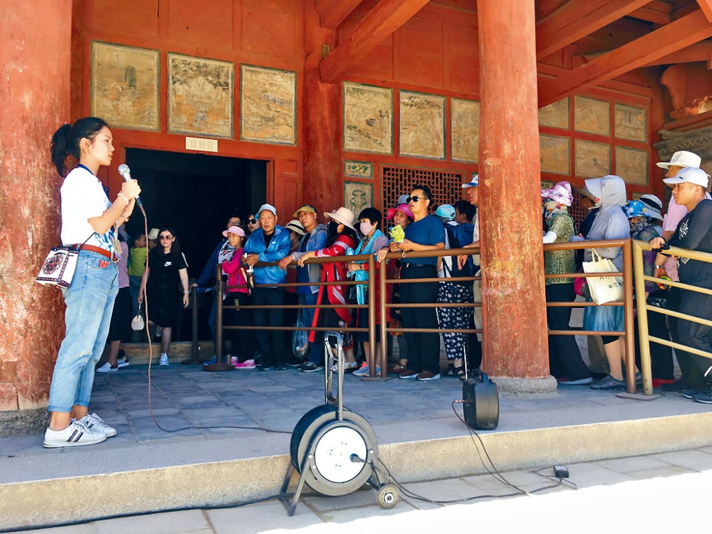 宋珮怡（左一）上周开展实习工作，为游客讲解洞窟奥秘。