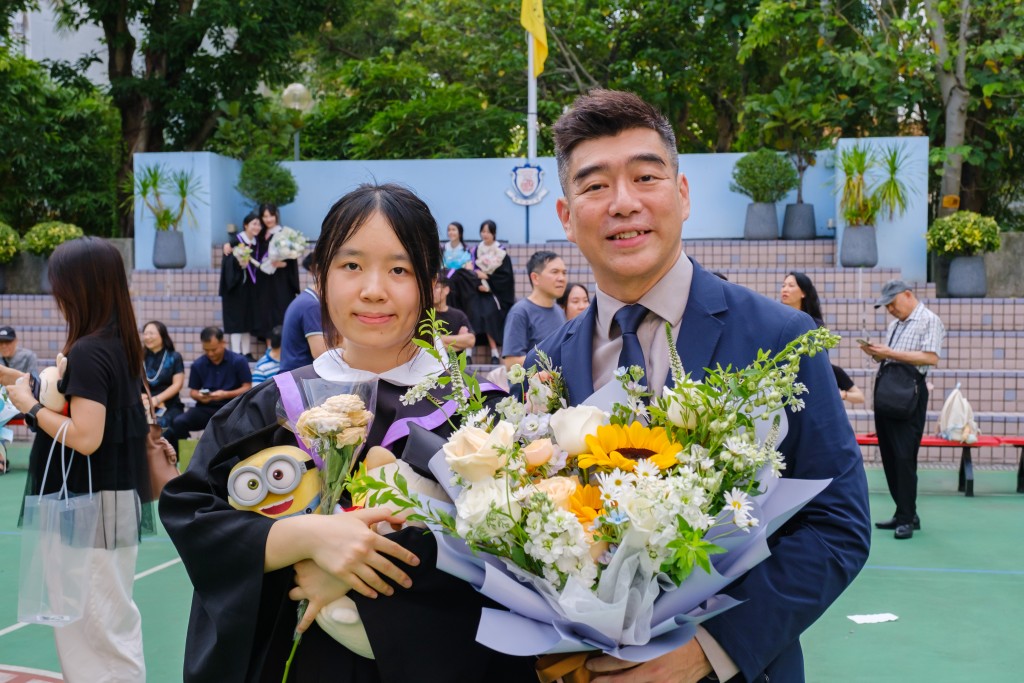 中学就读保良局董玉娣中学的应届DSE状元李心儿（左），是该校首位「女状元」，右为校长刘子聪。（学校提供）