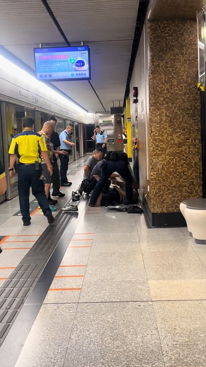 數名軍裝警及便衣警員將男子制服，按壓在地上。網上片段截圖