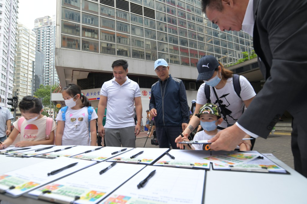香港友好協進會辦街站支持區議會方案，有市民簽名支持。（梁譽東攝）