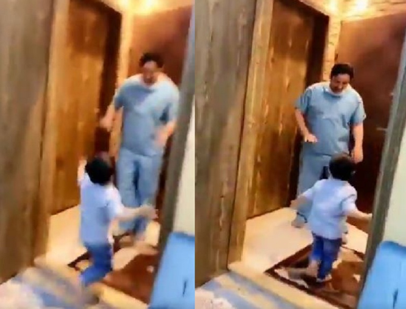 一名小孩歡喜地直奔向剛從醫院回家的醫護爸爸,卻被爸爸連忙制止。網圖