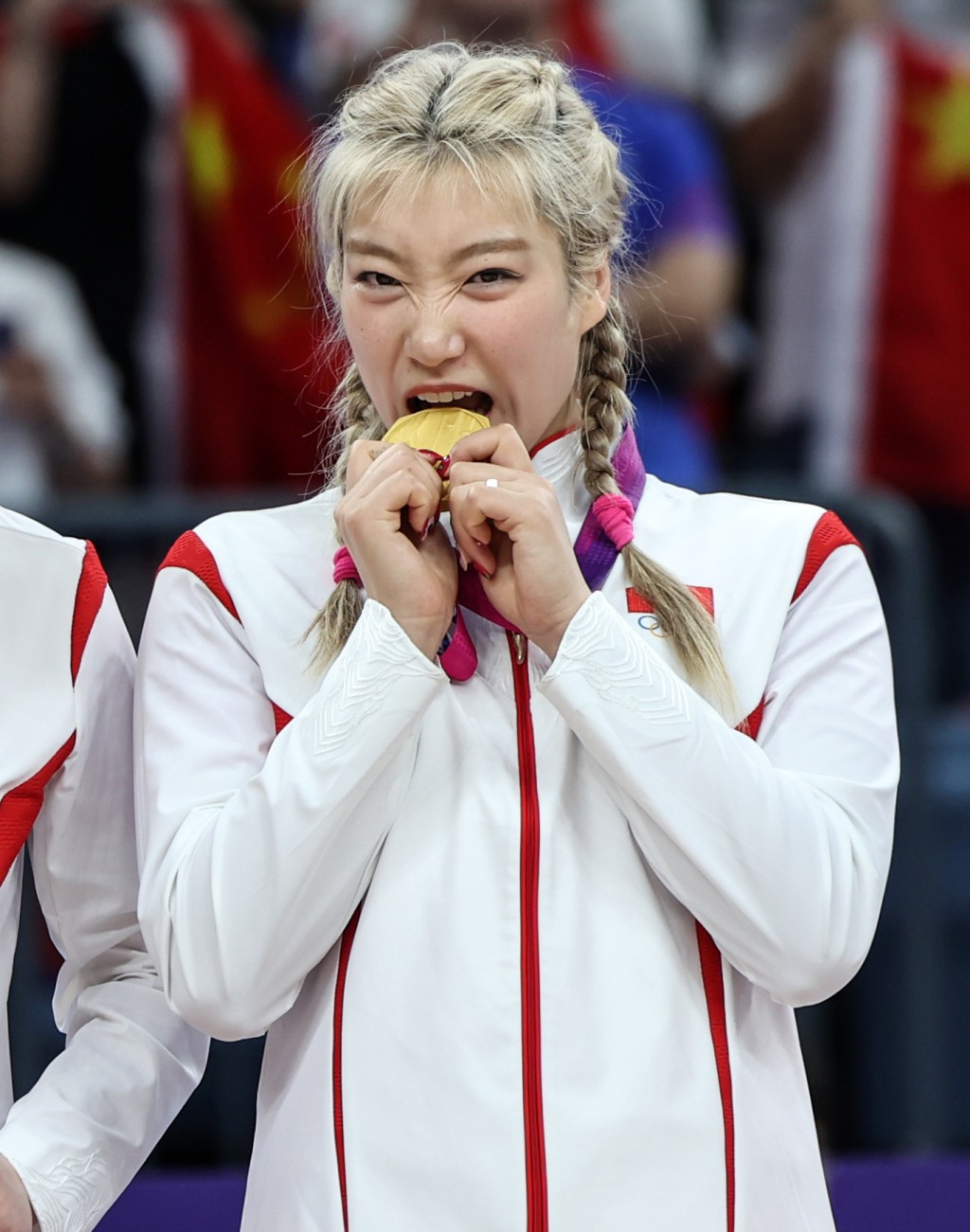 中国队球员李梦在颁奖仪式上「咬金牌」。新华社