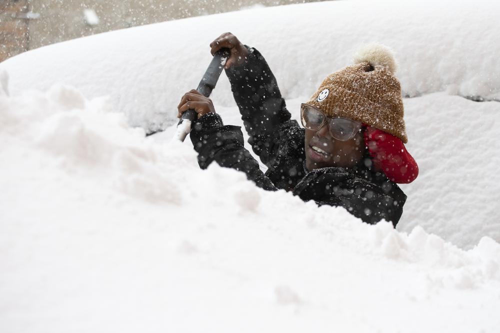 居民忙於剷雪。AP