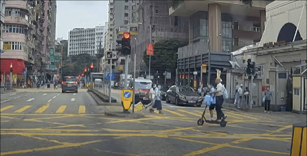 油麻地一名男子駕駛電動滑板車，並載著一名穿校服的兒童在馬路上飛馳。Youtube 車Cam特警片段截圖