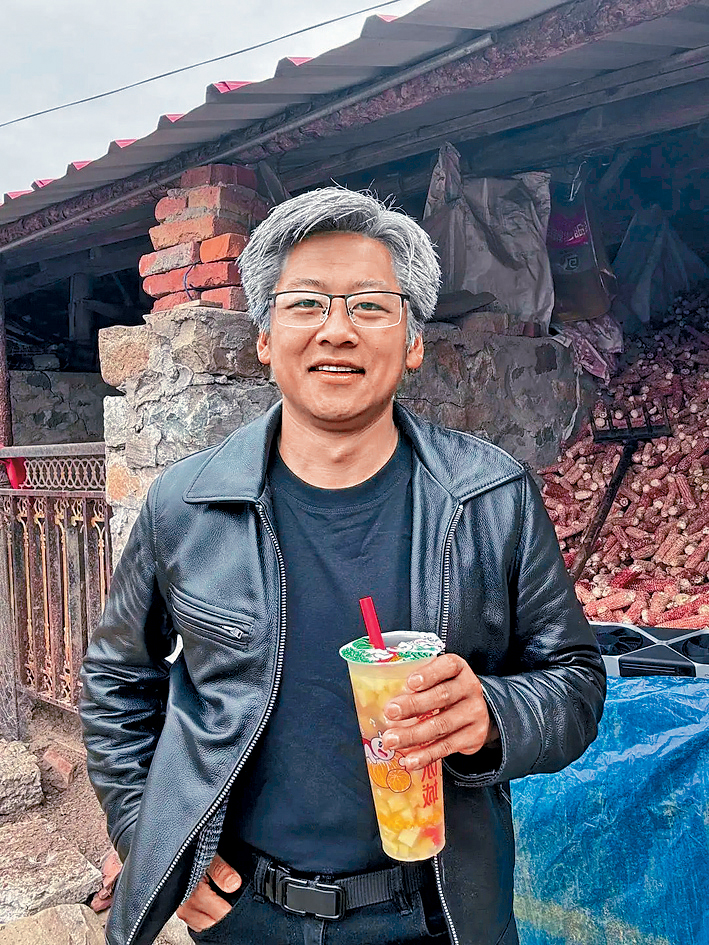 楊洋身穿黑色皮夾克，手持一杯蜜雪冰城飲品。